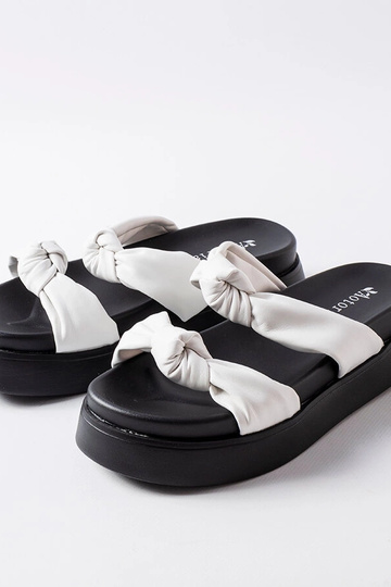Witte slippers op een...