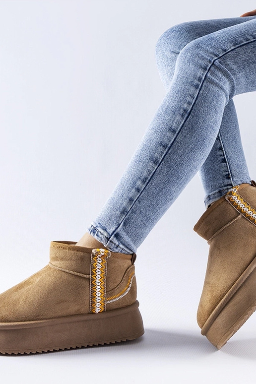 Donkerbeige sneeuwlaarzen op een... Donkerbeige sneeuwlaarzen op een...