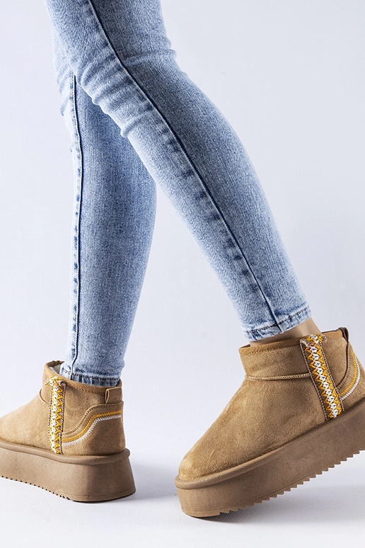 Donkerbeige sneeuwlaarzen op een... Donkerbeige sneeuwlaarzen op een...