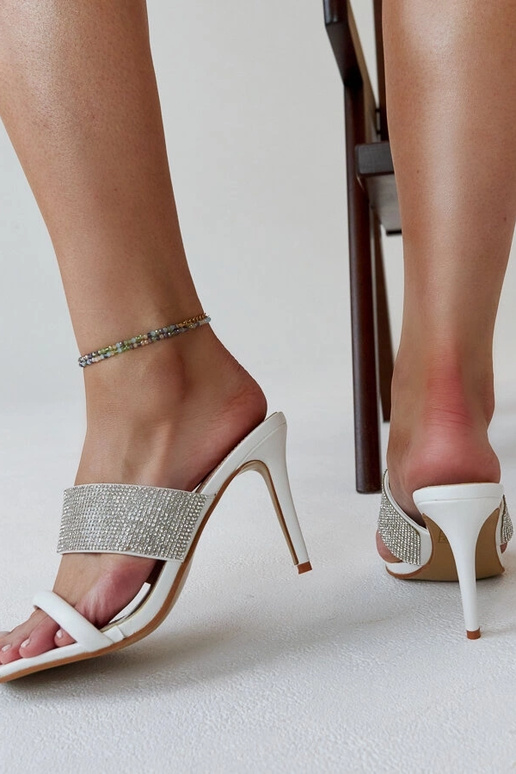 Hvide højhælede muldyr dekoreret med... Hvide højhælede muldyr dekoreret med...