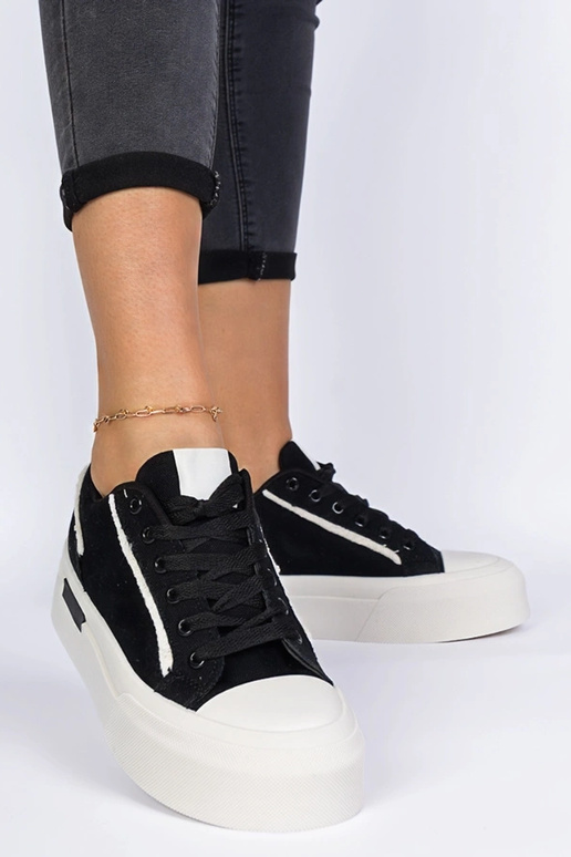 Zwarte damessneakers van stof op een... Zwarte damessneakers van stof op een...