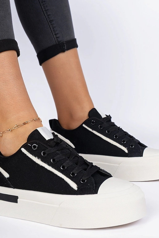 Zwarte damessneakers van stof op een... Zwarte damessneakers van stof op een...