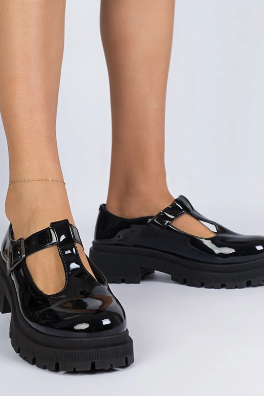 Zwarte lakinstapschoenen op een...