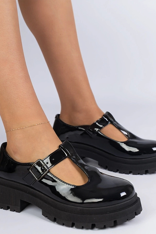 Zwarte lakinstapschoenen op een...