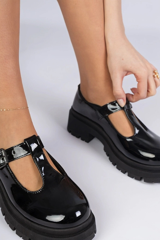 Zwarte lakinstapschoenen op een...