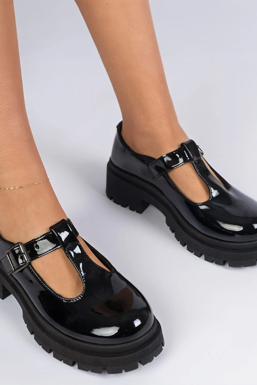 Zwarte lakinstapschoenen op een...