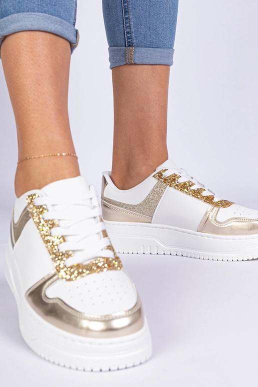 Gouden damessneakers op een dikke... Gouden damessneakers op een dikke...