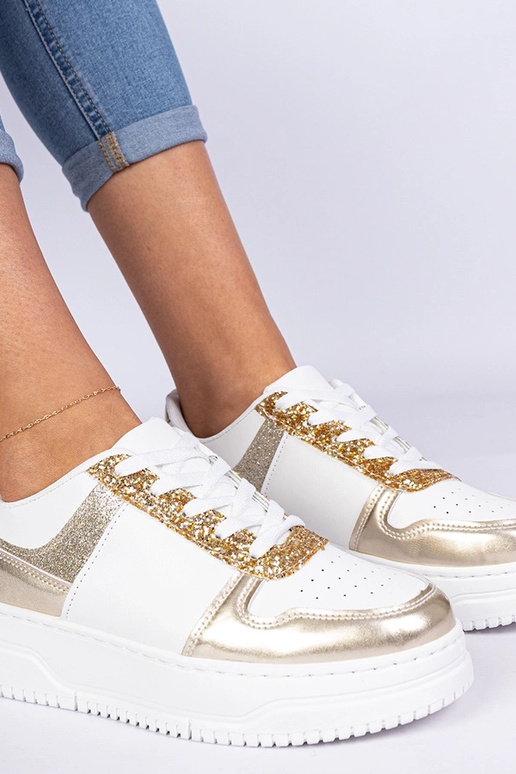 Gouden damessneakers op een dikke... Gouden damessneakers op een dikke...