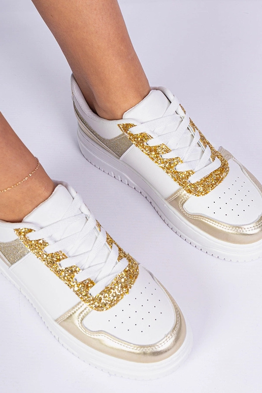 Gouden damessneakers op een dikke... Gouden damessneakers op een dikke...