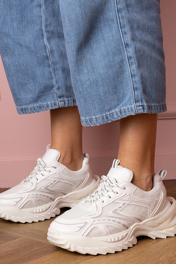 Witte dames sneakers op een...