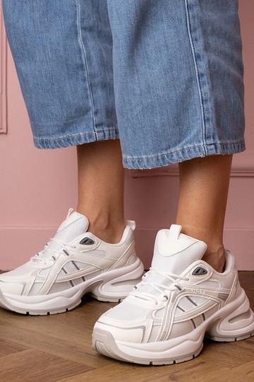 Witte dames sneakers op een...