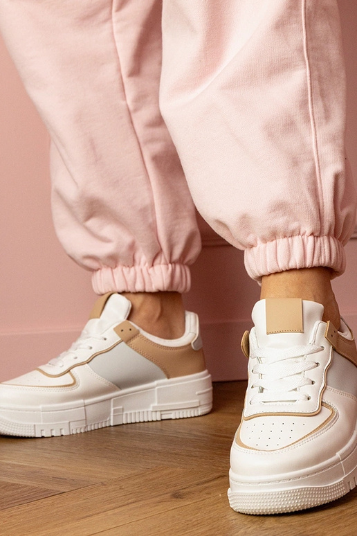 Wit-beige dames sneakers op een... Wit-beige dames sneakers op een...