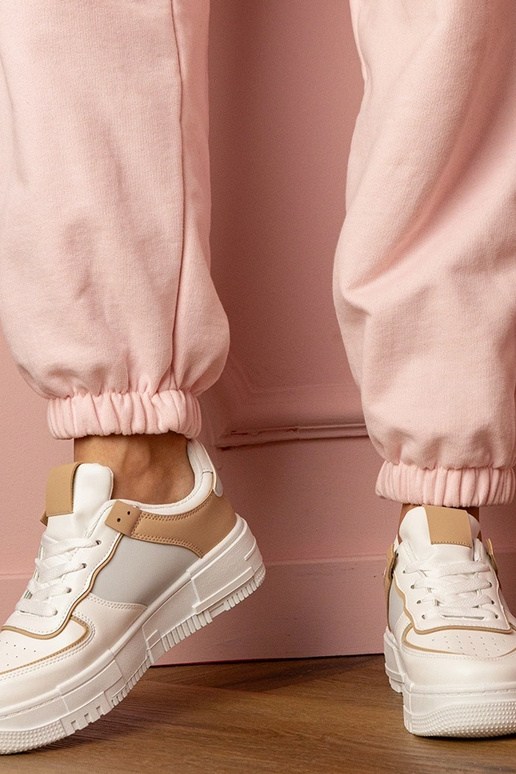 Wit-beige dames sneakers op een... Wit-beige dames sneakers op een...