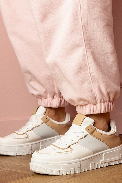 Wit-beige dames sneakers op een... Wit-beige dames sneakers op een...