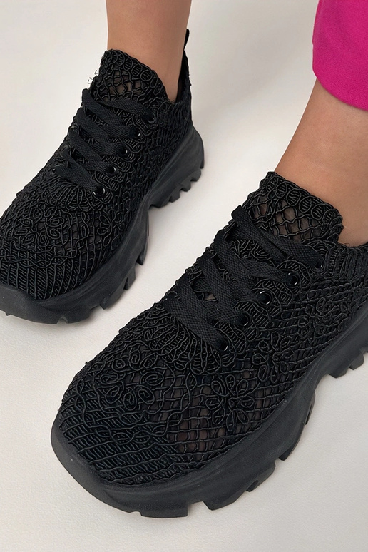 Zwarte gehaakte sneakers op een...