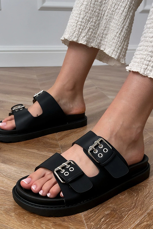 Zwarte slippers met gespen op de... Zwarte slippers met gespen op de...