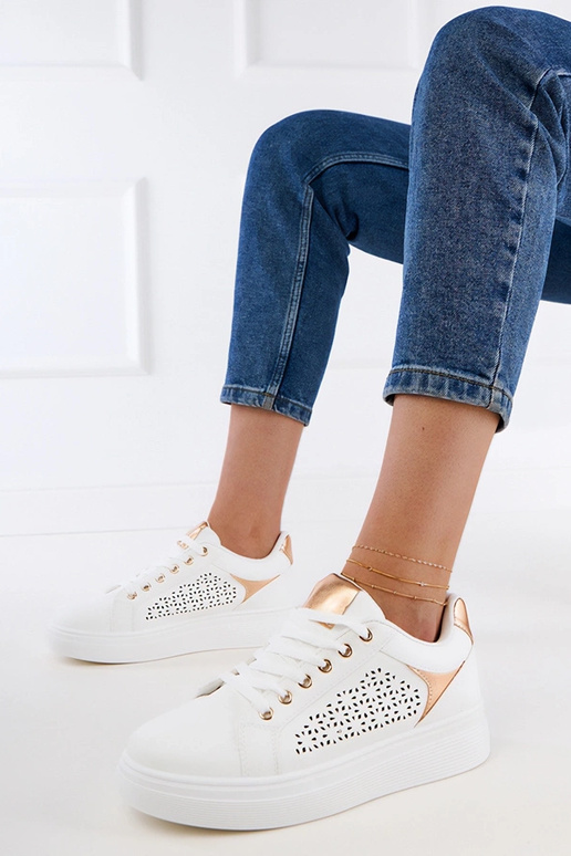 Witte sneakers met gouden details op...