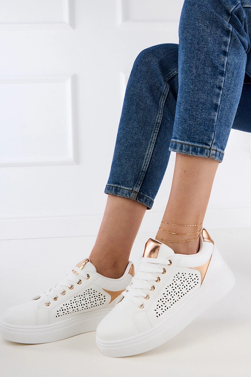 Witte sneakers met gouden details op...