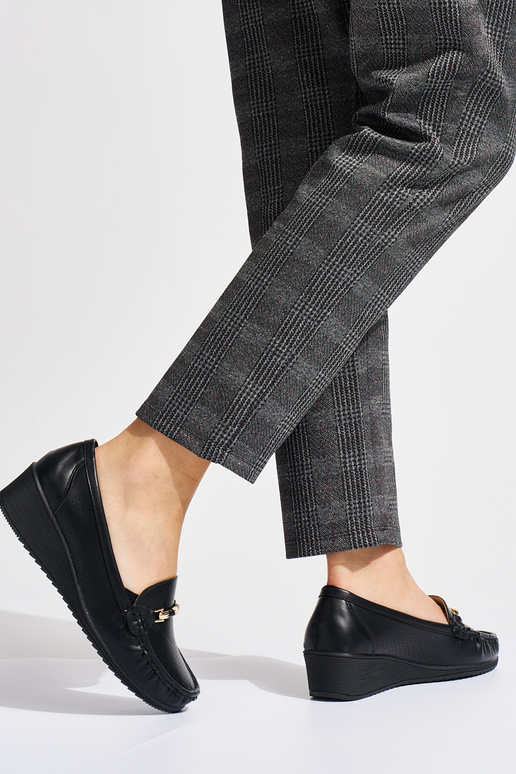 zwarte opengewerkte mocassins op een...