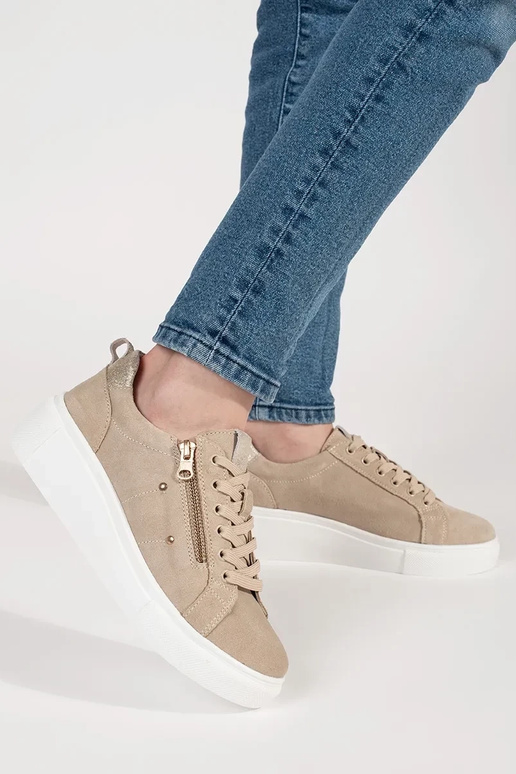 Zandkleurige sneakers model op een... Zandkleurige sneakers model op een...