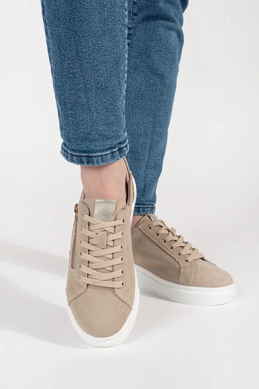 Zandkleurige sneakers model op een... Zandkleurige sneakers model op een...