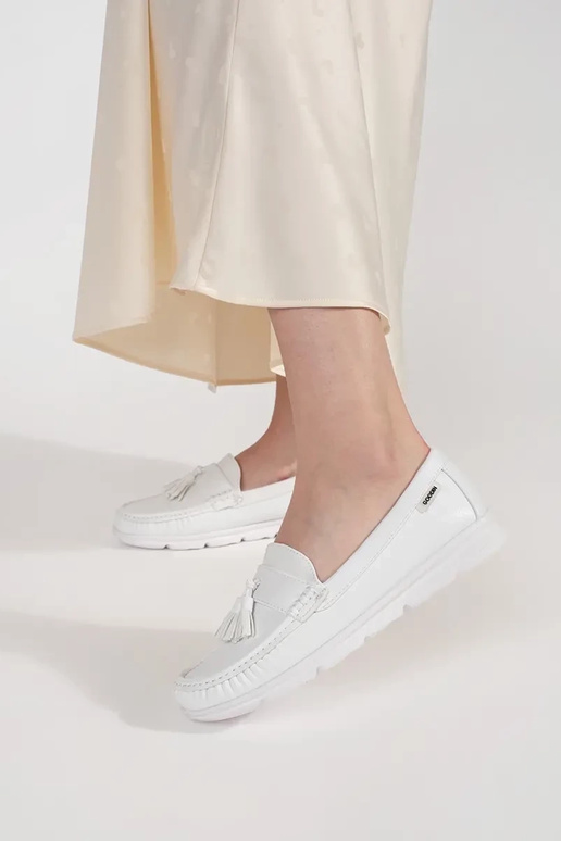 Witte instappers met franjes op een... Witte instappers met franjes op een...