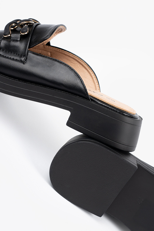 Zwarte slippers van kunstleer op een...