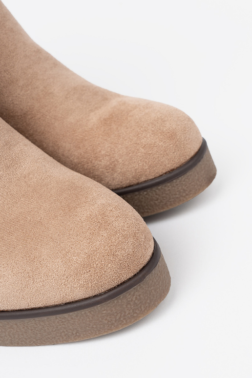 beige laarzen op een Inig met decoratieve gesp