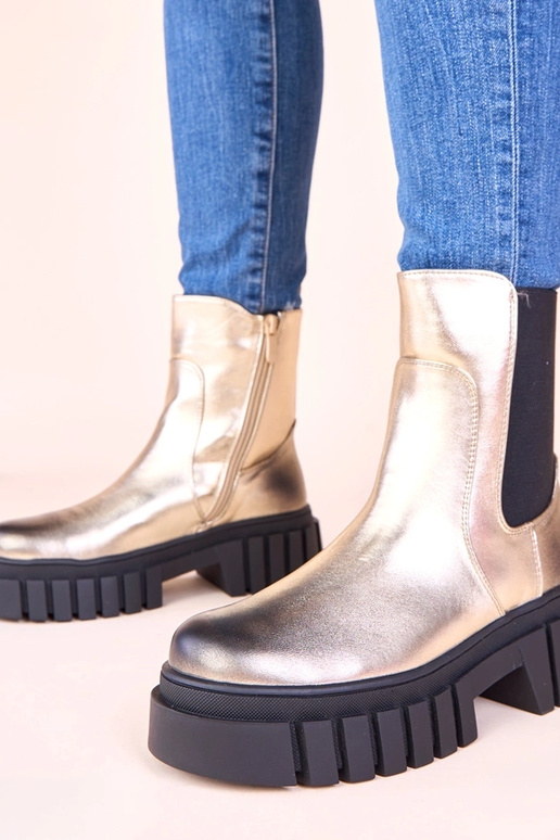 Gouden enkellaarsjes op een platform...