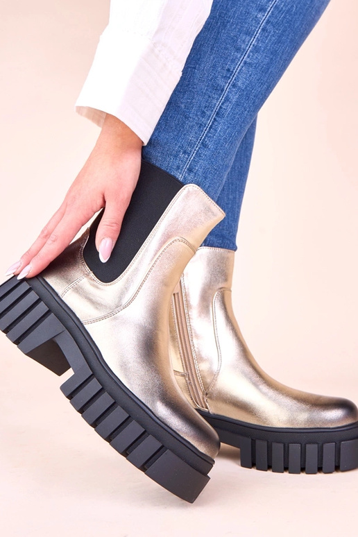 Gouden enkellaarsjes op een platform...