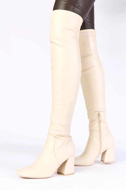 Zandkleurige lange laarzen boven de...