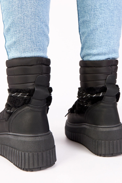 Zwarte sneeuwlaarzen op een platform...