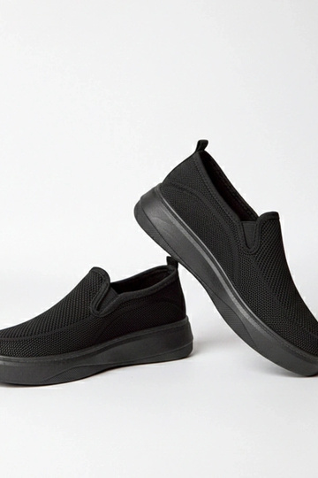 Zwarte stoffen sneakers op...