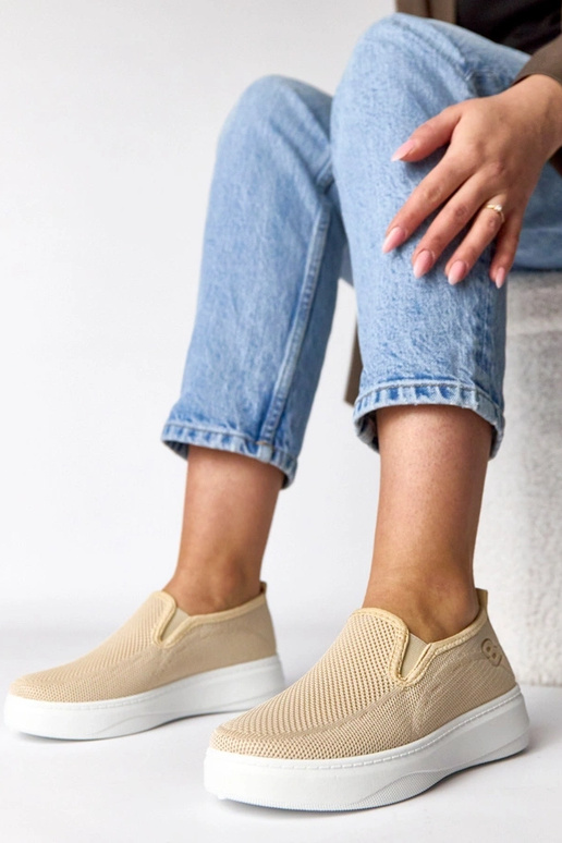 Zandkleurige stoffen sneakers op een...