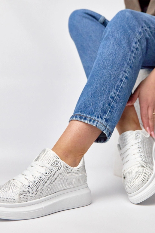 Witte sneakers op een platform...