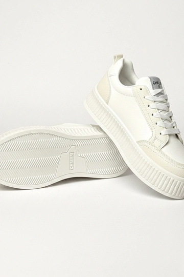 Witte sneakers op een...