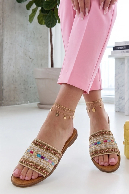 Sandkleurige pantoffels versierd met...