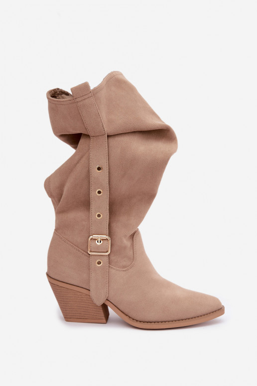 gekruiste dames lange laarzen in cowboystijl met riemen en hakken in zand Adria